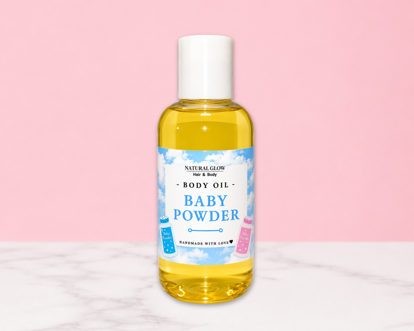 A bottle of Natural Glow For & Baby Baby Powder Body Oil, filled with yellow liquid and featuring a white cap, set against a pink background with a white marble surface.