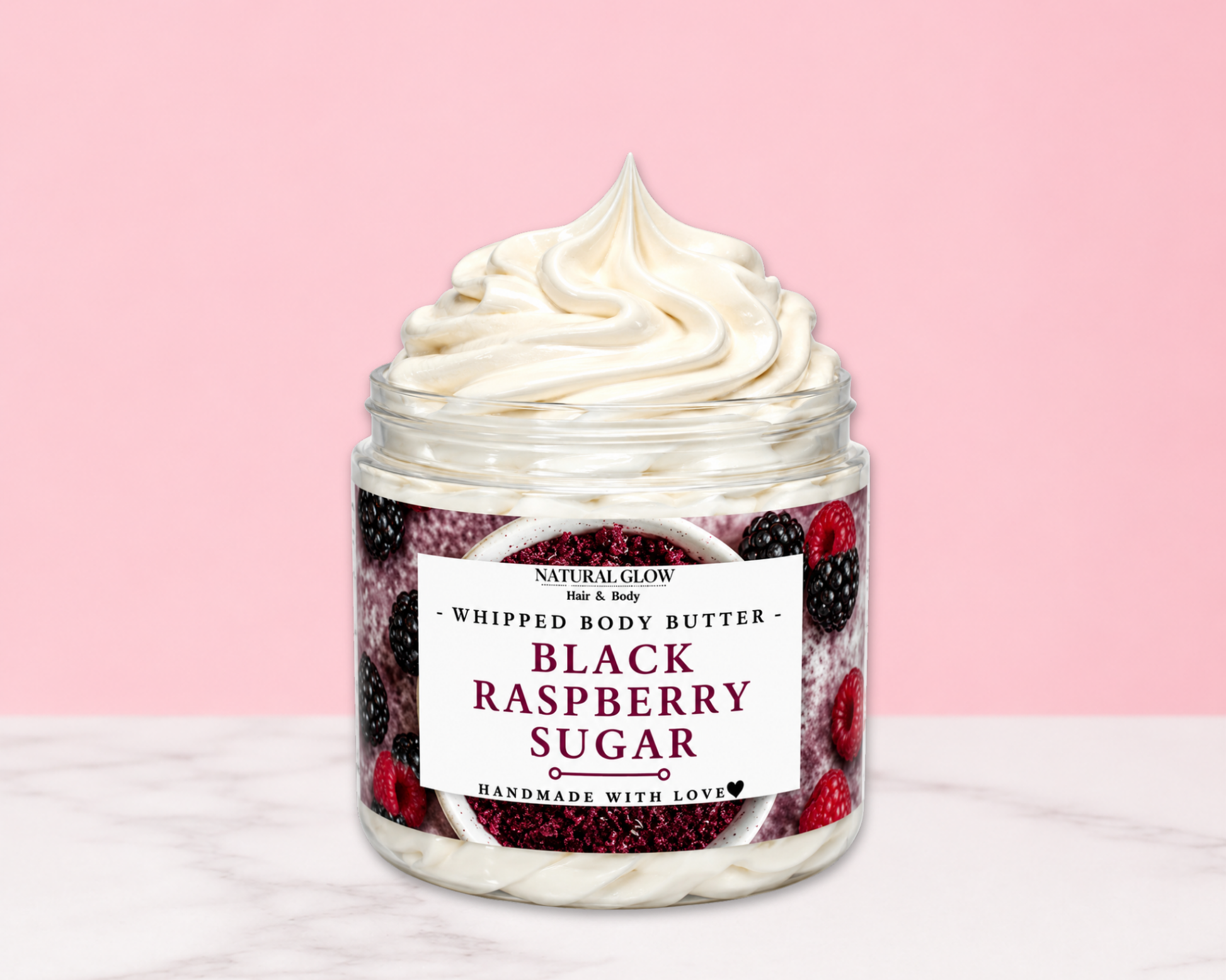 Natural Glow Black Raspberry Sugar whipped body butter in a jar with cream-colored butter swirl, pink background, and white marble surface