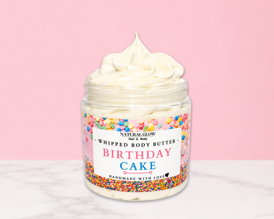 Natural Glow Birthday Cake whipped body butter in a jar with cream-colored butter swirl, pink background, and white marble surface