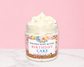 Natural Glow Birthday Cake whipped body butter in a jar with cream-colored butter swirl, pink background, and white marble surface