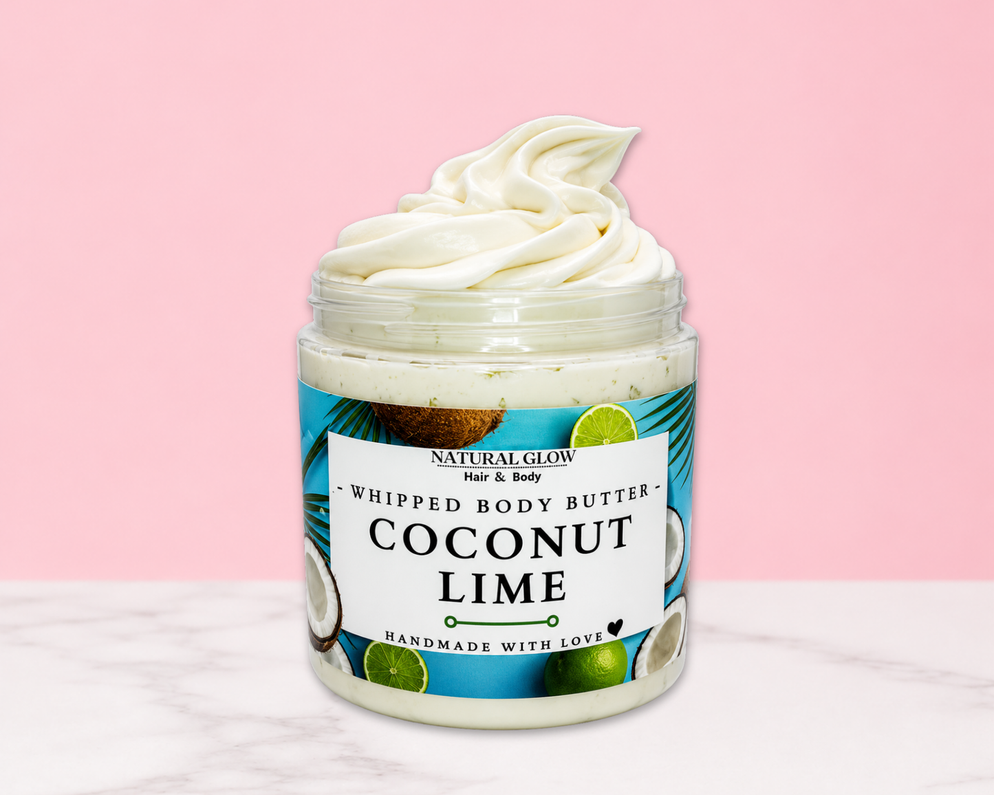Natural Glow Coconut Lime whipped body butter in a jar with cream-colored butter swirl, pink background, and white marble surface