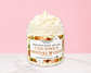 Natural Glow Coconut Sandalwood whipped body butter in a jar with cream-colored butter swirl, pink background, and white marble surface