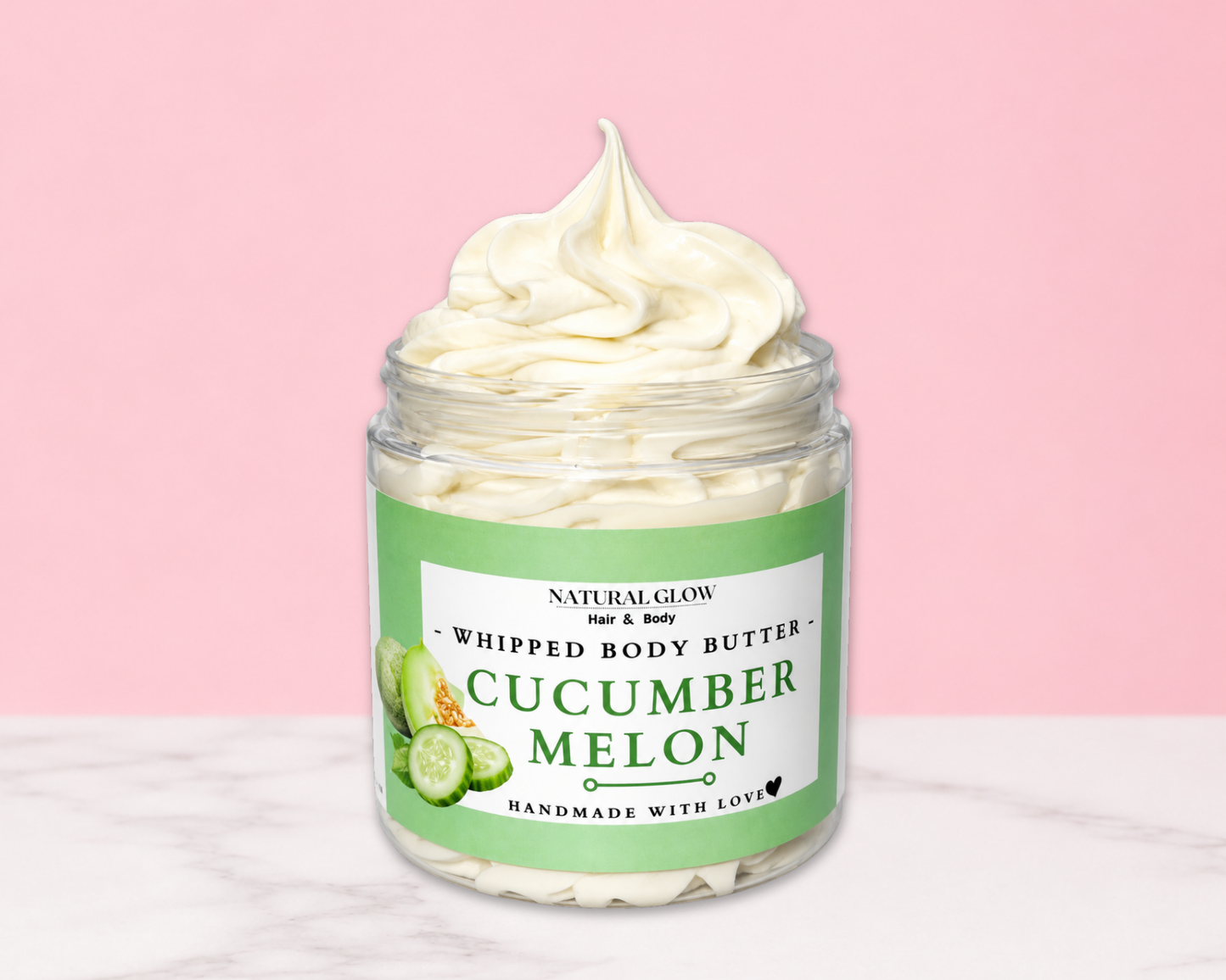 Natural Glow Cucumber Melon whipped body butter in a jar with cream-colored butter swirl, pink background, and white marble surface