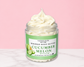 Natural Glow Cucumber Melon whipped body butter in a jar with cream-colored butter swirl, pink background, and white marble surface