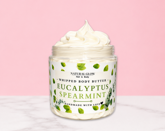 Natural Glow Eucalyptus & Spearmint whipped body butter in a jar with cream-colored butter swirl, pink background, and white marble surface