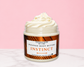 Natural Glow Instinct mens whipped body butter in a jar with cream-colored butter swirl, pink background, and white marble surface