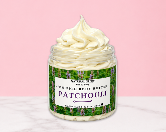 Natural Glow Patchouli whipped body butter in a jar with cream-colored butter swirl, pink background, and white marble surface
