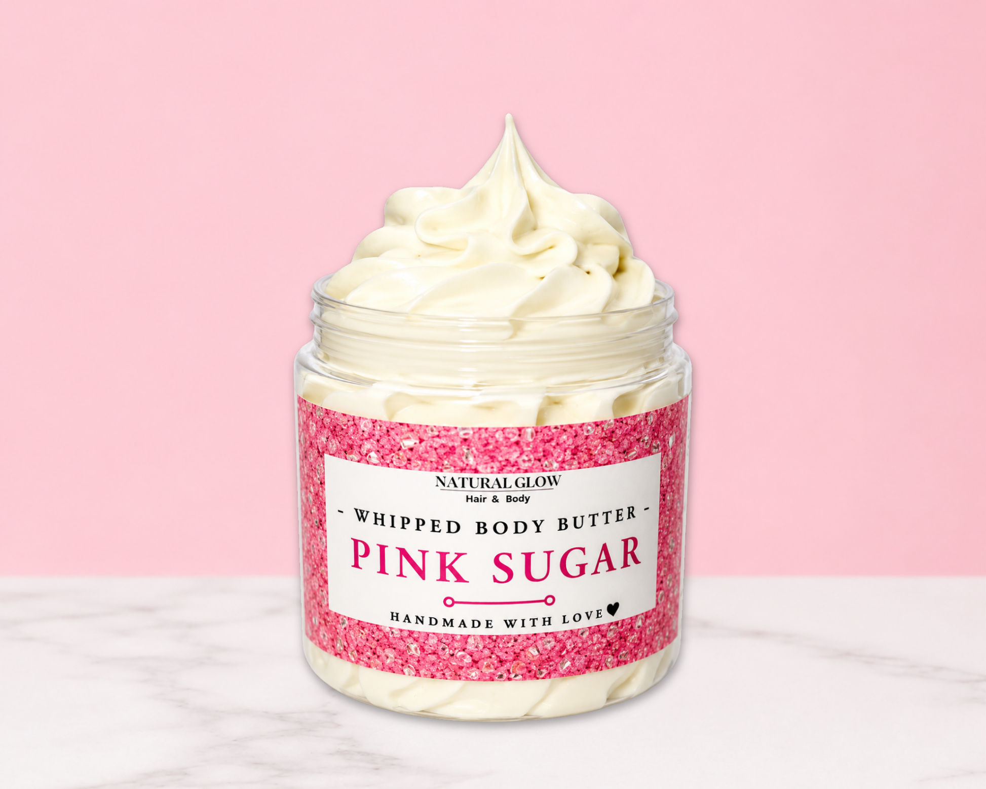 Natural Glow Pink Sugar whipped body butter in a jar with cream-colored butter swirl, pink background, and white marble surface