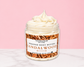 Natural Glow Sandalwood whipped body butter in a jar with cream-colored butter swirl, pink background, and white marble surface