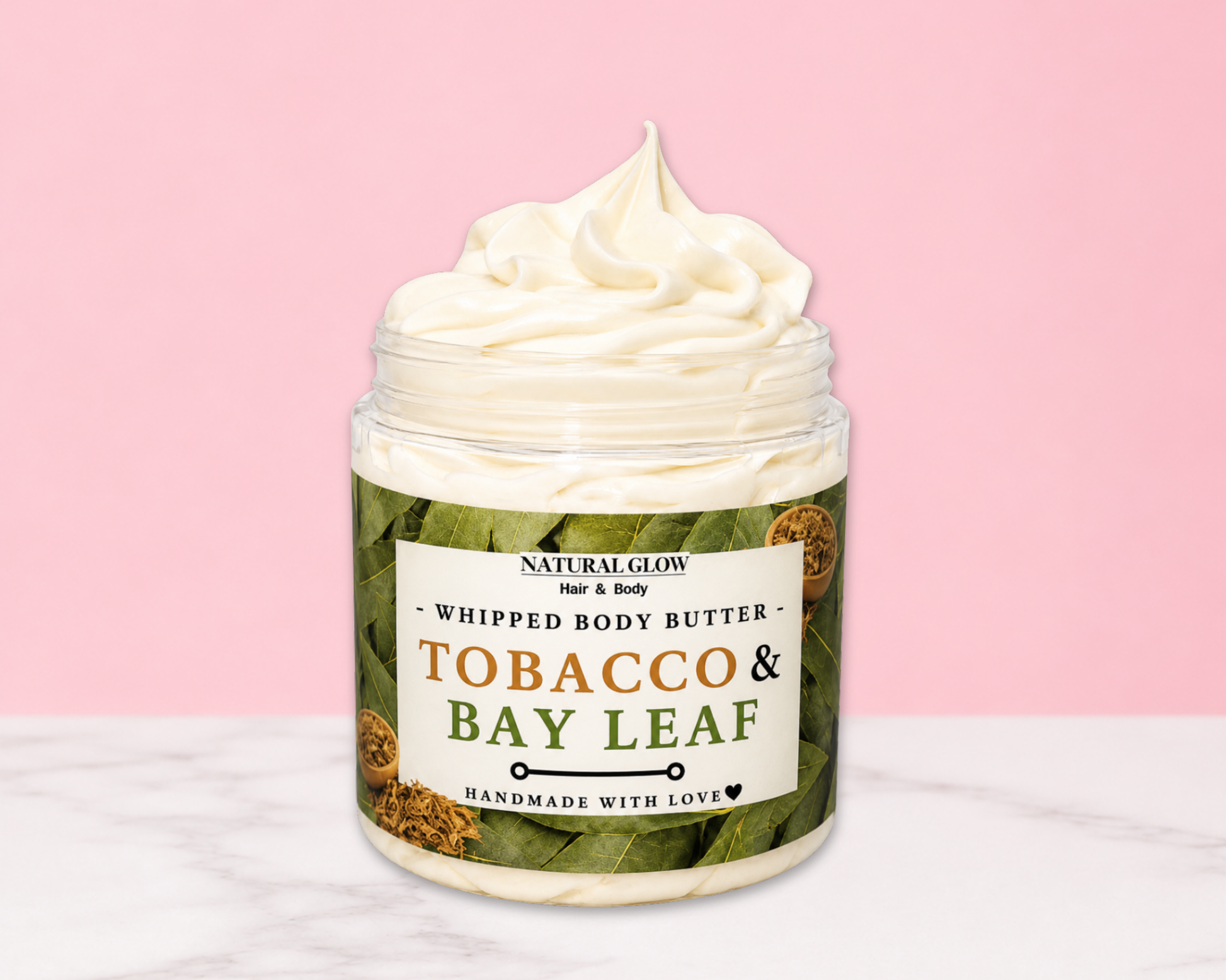 Natural Glow Tobacco & Bay Leaf  men's whipped body butter in a jar with cream-colored butter swirl, pink background, and white marble surface
