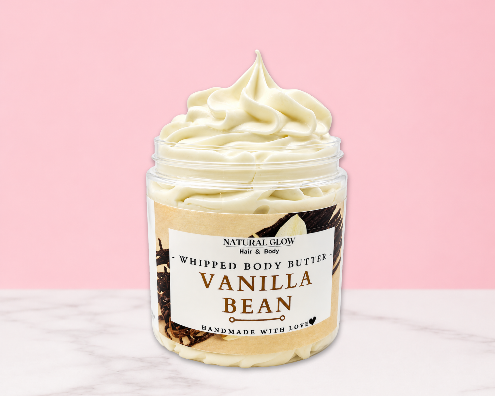 Natural Glow Vanilla Bean whipped body butter in a jar with cream-colored butter swirl, pink background, and white marble surface