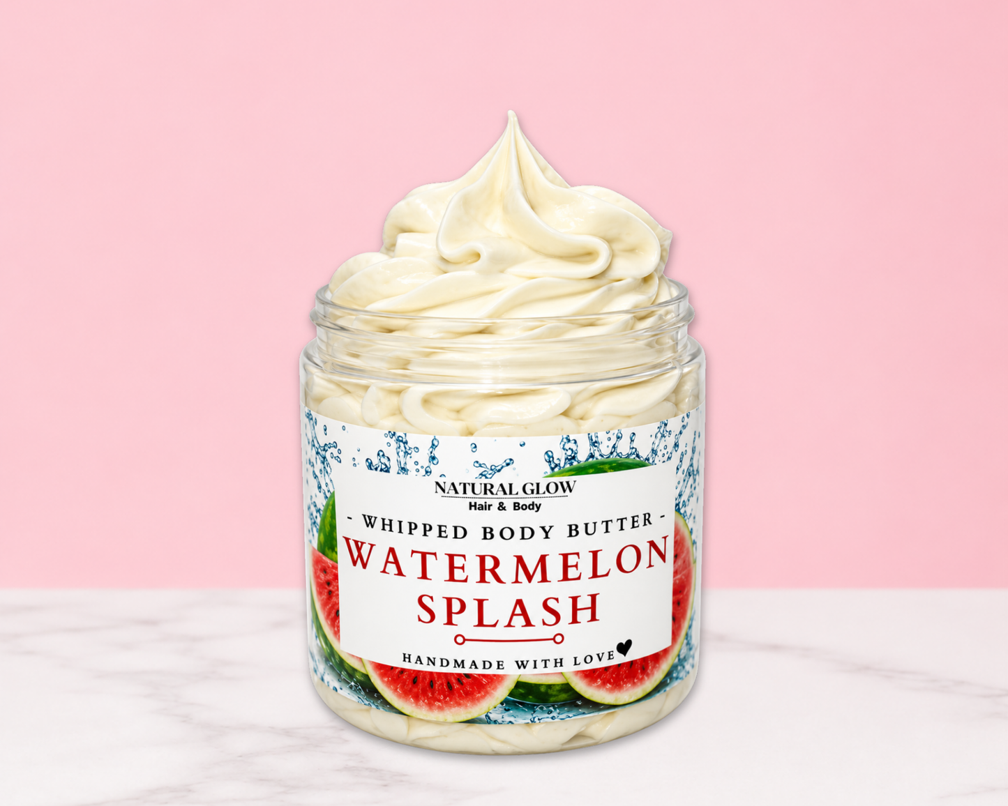 Natural Glow Watermelon Splash whipped body butter in a jar with cream-colored butter swirl, pink background, and white marble surface
