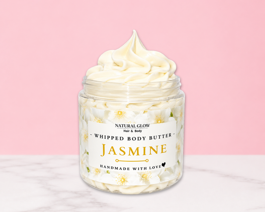 Natural Glow Jasmine whipped body butter in a jar with cream-colored butter swirl, pink background, and white marble surface