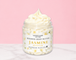 Natural Glow Jasmine whipped body butter in a jar with cream-colored butter swirl, pink background, and white marble surface