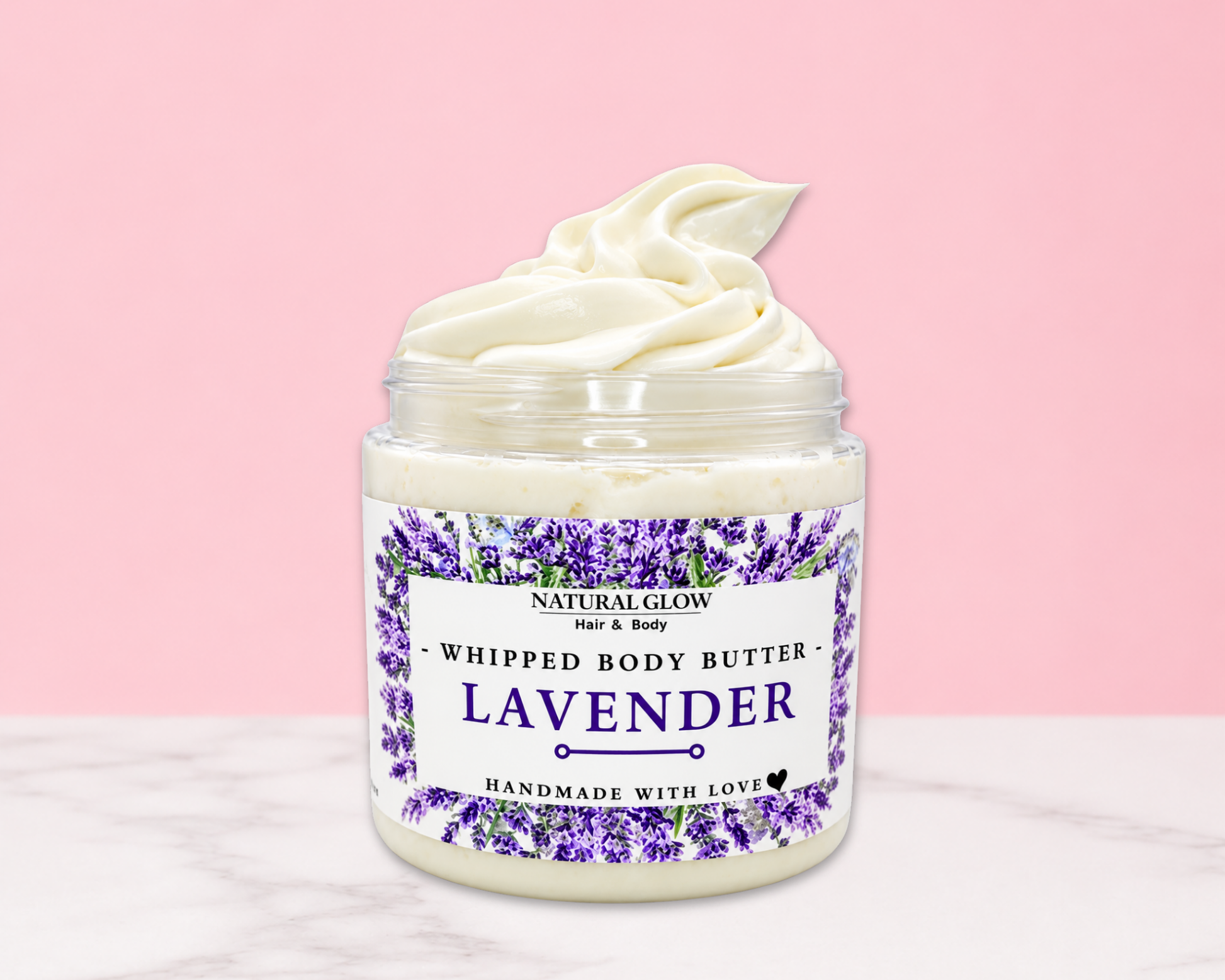 Natural Glow Lavender whipped body butter in a jar with cream-colored butter swirl, pink background, and white marble surface