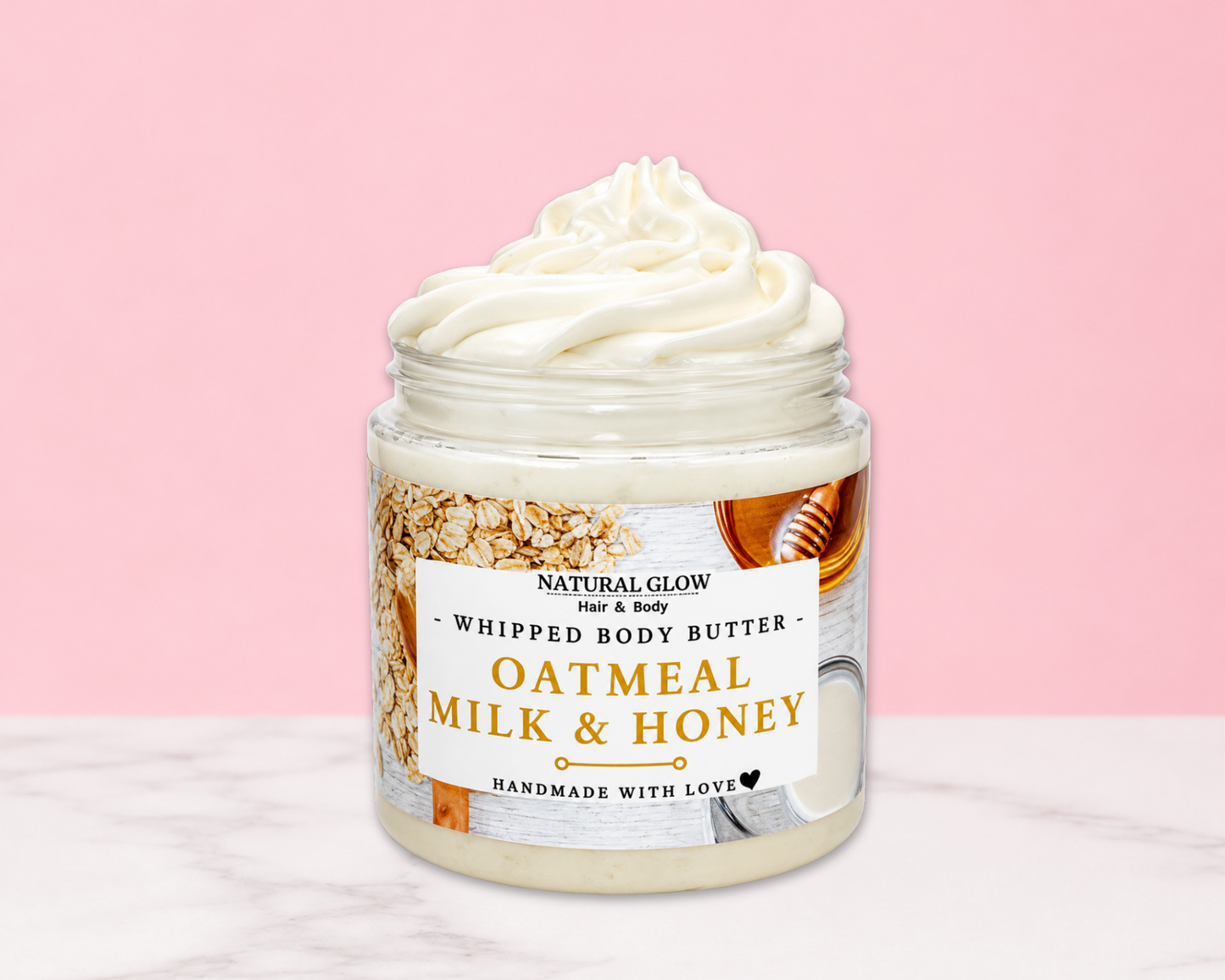 Natural Glow Oatmeal Milk and Honey whipped body butter in a jar with cream-colored butter swirl, pink background, and white marble surface