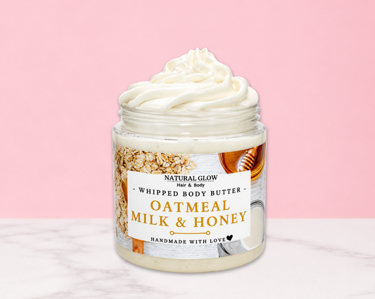 Natural Glow Oatmeal Milk and Honey whipped body butter in a jar with cream-colored butter swirl, pink background, and white marble surface