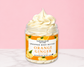 Natural Glow Orange Ginger whipped body butter in a jar with cream-colored butter swirl, pink background, and white marble surface